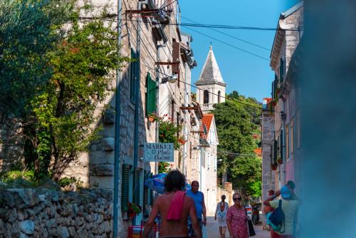 a group of people walking down a narrow street at Marceline in Prvić Luka