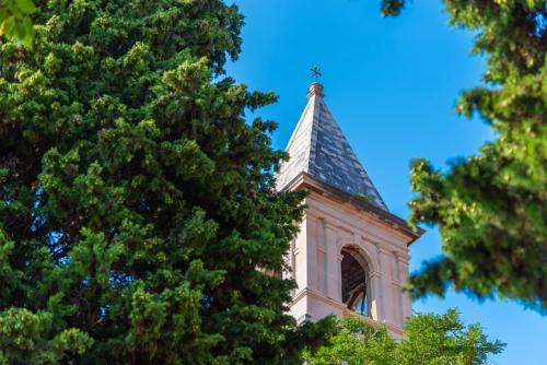 a tower with a steeple on top of a tree at Marceline in Prvić Luka
