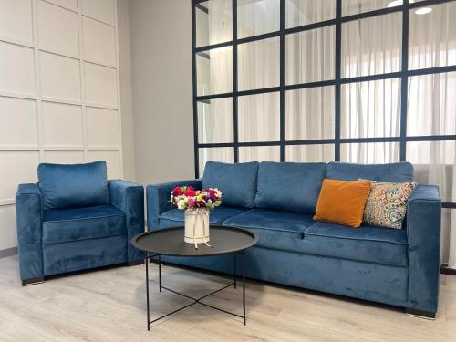 a blue couch and a table with a vase of flowers at Sweet Home Apart-Hotel in Yerevan
