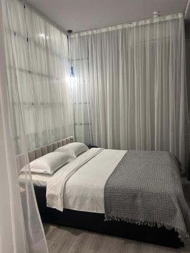 a bedroom with a bed with white drapes at Sweet Home Apart-Hotel in Yerevan
