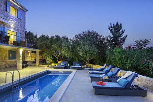 a patio with couches and a swimming pool at Marceline in Prvić Luka