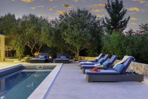 a row of lounge chairs next to a swimming pool at Marceline in Prvić Luka