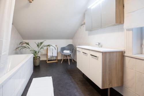 ein Badezimmer mit einem Waschbecken und einer Badewanne in der Unterkunft Inn Joy Apartments - Sankt Gallen West in St. Gallen