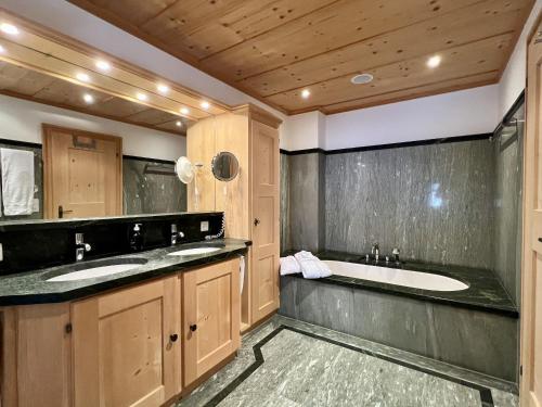 a bathroom with two sinks and a tub at Chalet Mira Golf in Sagogn