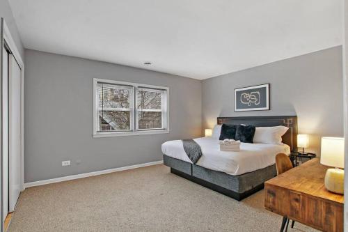 1 dormitorio con 1 cama, 1 mesa y 2 ventanas en 3BR & 2BA Tranquil Apt in Prime Location - Church 301, en Evanston