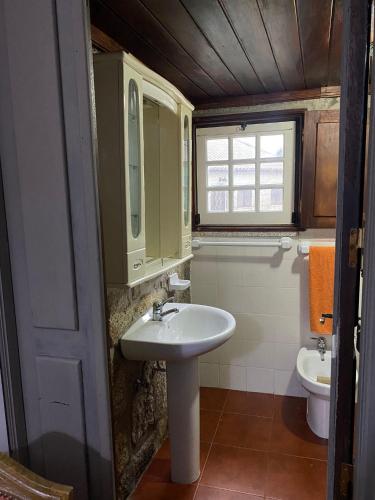 a bathroom with a sink and a toilet at Casa penedo do bento in Soajo