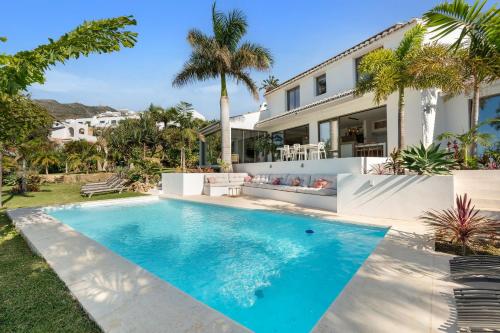 a swimming pool in front of a house at Bed & Breakfast in Villa Eden Palm in Benalmádena