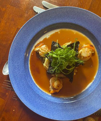 a bowl of soup with shrimp and greens on a table at The Postgate Inn in Egton