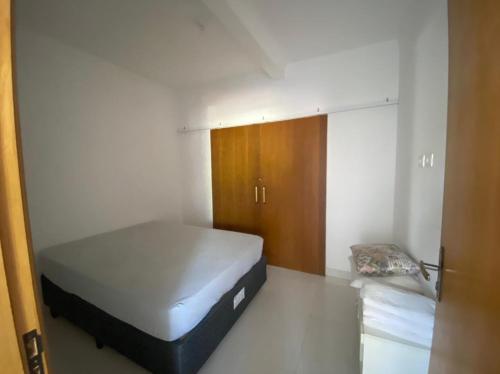 ein kleines Schlafzimmer mit einem Bett und einem Schrank in der Unterkunft Casa na praia da enseada - Guarujá in Guarujá