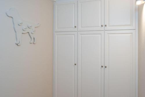 a white closet with a cat on the wall at Haus-Fili-Wohnung-2-EG in Wenningstedt