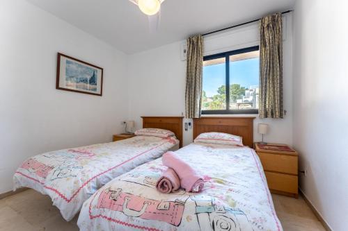 a bedroom with two beds with a pink doll laying on them at Sea Views Torreoceano 7 in Mijas Costa