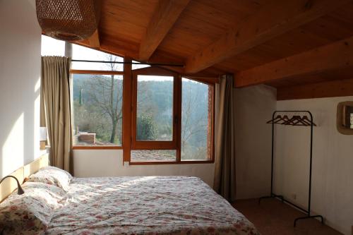 Un dormitorio con una cama y una ventana grande. en Casa ecológica en plena naturaleza, en Arboli