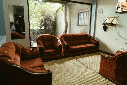 un soggiorno con 2 sedie in pelle e un divano di Hotel IntyKucha a San Rafael