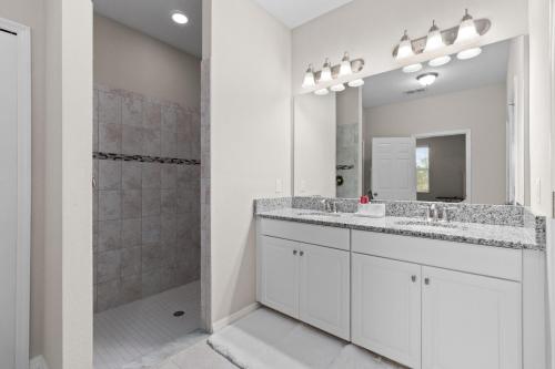 a bathroom with two sinks and a shower at Luxurious Tampa Bay Area Home in Serene Community! in Riverview