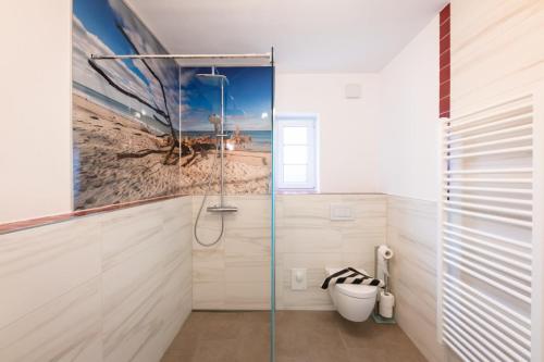 a bathroom with a shower with a picture of the beach at DHH 7 Haus am Wiesengrund in Prerow