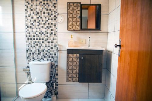 ein Badezimmer mit einem WC, einem Waschbecken und einem Spiegel in der Unterkunft Incrivel casa c otima localizacao em Foz do Iguacu in Foz do Iguaçu