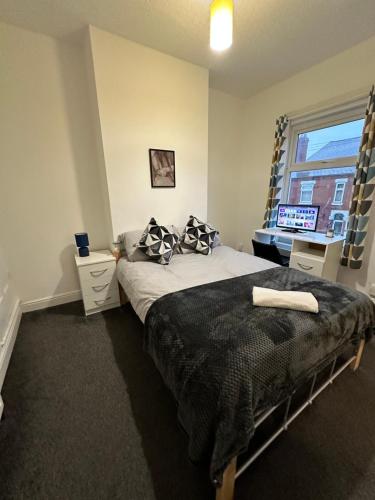 a bedroom with a bed and a window with a television at Lovely Town house Room 2 in Parkside