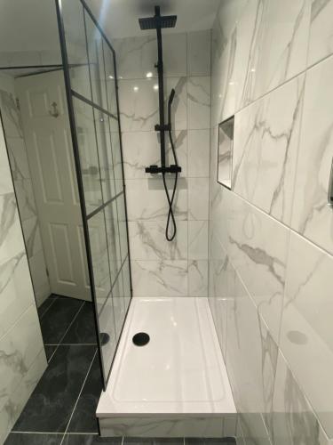 a bathroom with a shower with a cross on the wall at The Cwtch, Log Fire, Sleeps 6, Nr Zip World, Brecon and Bike Park Wales in Aberdare