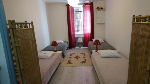 a small room with two beds and two windows at Dortoir Bulgarana - Bourg Argental in Bourg-Argental