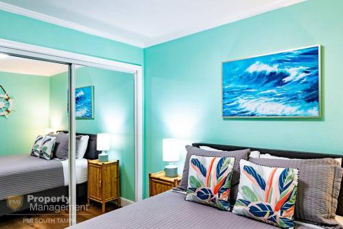 a bedroom with blue walls and a bed with a mirror at Cool Breeze - Sunset views like no other in Tampa