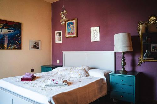a bedroom with a large bed with purple walls at B&B Colle Vignoni in Barberino di Mugello