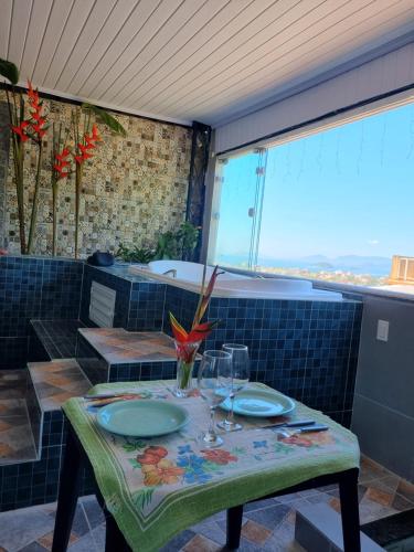 Una mesa con platos y copas de vino encima. en Suite Bela vista Muriqui Cantinho Feliz, en Mangaratiba