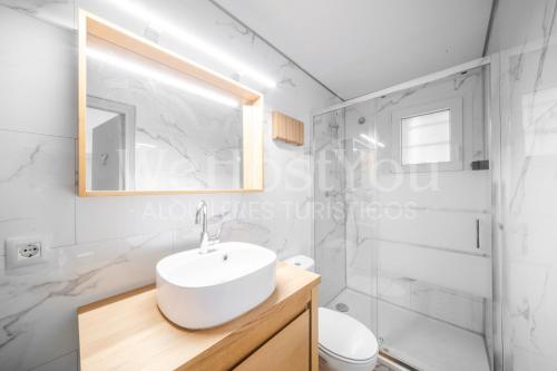 a white bathroom with a sink and a shower at Magnifique Maison Bramer 14, Roses - WeHostYou in Roses