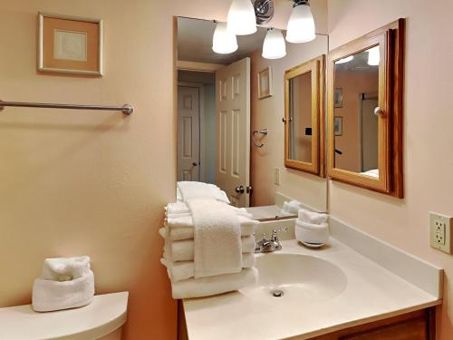 een badkamer met een wastafel, een spiegel en handdoeken bij Palm Beach Club 113 in Pensacola Beach