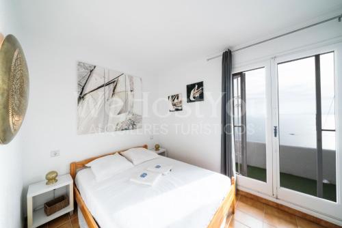 a bedroom with a bed and a large window at Magnifique Maison Bramer 14, Roses - WeHostYou in Roses