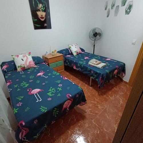 two beds in a room with pink flamingos at Pililla in Bedmar