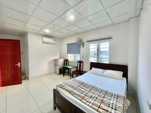 Un dormitorio con una cama y una mesa. en Thủy Quỳnh hotel, en Xóm Bên Ðông