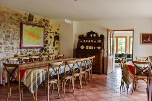 une salle à manger avec une longue table et des chaises dans l'établissement Gîte de Peyrefitte, à Lescure