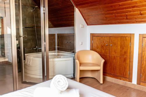 y baño con bañera y silla. en Duplex lujo Monte Oiz 4 habitaciones y 2 plazas de parking, en Sierra Nevada