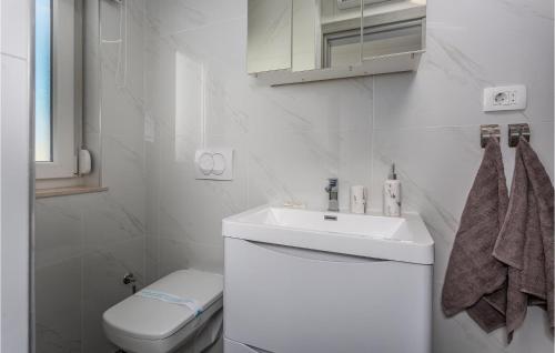 Baño blanco con lavabo y aseo en Beautiful Apartment In Cavle With Wi-fi, en Čavle