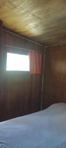 um quarto com uma cama e uma janela em Chacrita Aguaribay em Villa Argentina