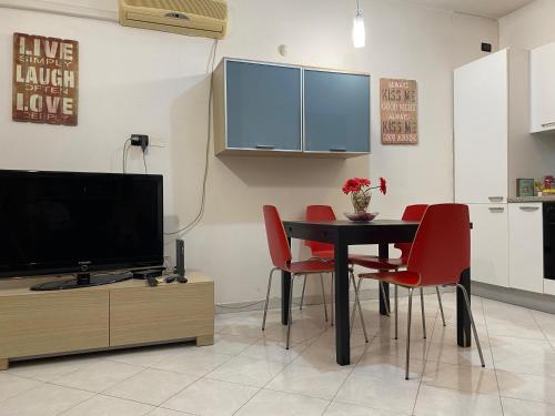 une salle à manger avec une table et des chaises rouges dans l'établissement Centro città con le comodità, à Livourne