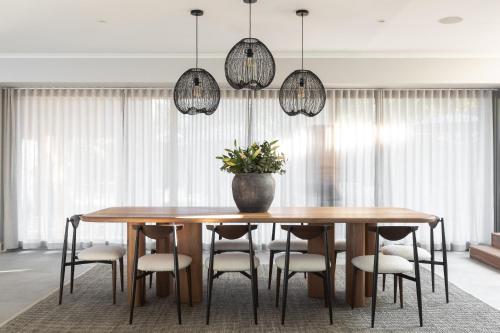 a dining room table with chairs and pendant lights at Escape to the Beach in Wilderness