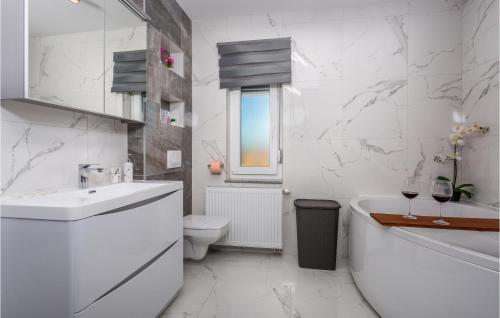 La salle de bains blanche est pourvue d'une baignoire, de toilettes et d'un lavabo. dans l'établissement Gorgeous Apartment In Cavle With Wi-fi, à Čavle