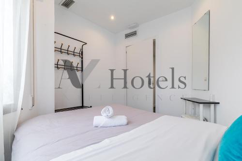a white bedroom with a bed with a clock on it at AYZ Ulises - Auto check-in property in Madrid