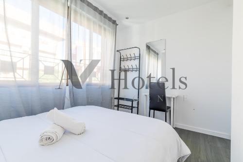 a white bedroom with a white bed and a window at AYZ Ulises - Auto check-in property in Madrid