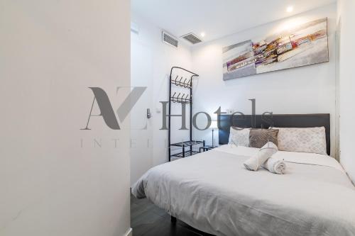 a bedroom with a large white bed with a sign on the wall at AYZ Ulises - Auto check-in property in Madrid