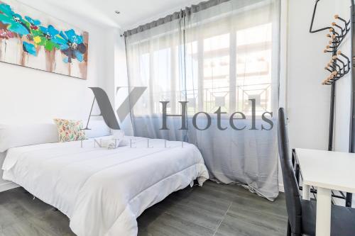 a white bedroom with a bed and a window at AYZ Ulises - Auto check-in property in Madrid