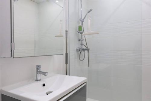 une salle de bain blanche avec un lavabo et une douche dans l'établissement Bel appartement rénové VUE MER au port de de PERROS-GUIREC Ref 841, à Perros-Guirec
