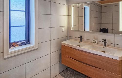 La salle de bains est pourvue d'un lavabo et d'un miroir. dans l'établissement Lovely Home In Tuddal With House A Mountain View, à Tuddal