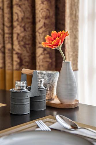 Eine Vase mit einer Blume auf dem Tisch. in der Unterkunft De 4 seizoenen in Loenen