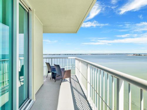 a balcony with chairs and a view of the water at Tristan Towers #11E in Pensacola Beach