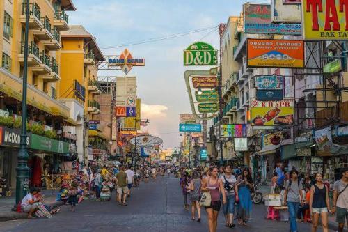 una multitud de personas caminando por una concurrida calle de la ciudad en wonderful hostel khaosan, en Bangkok