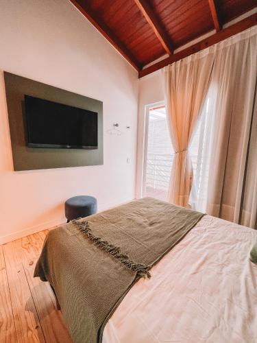 a bedroom with a bed and a tv on the wall at Casa Cancun Hotel Boutique & Eventos in Penha
