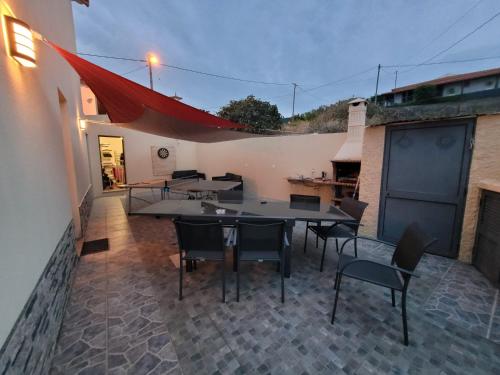 eine Terrasse mit einem Tisch und Stühlen sowie ein Gebäude in der Unterkunft Maison avec vue exceptionnelle sur l'océan - 5 mn du centre ville in Santa Cruz