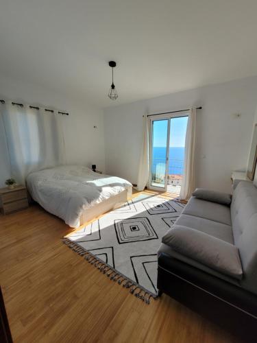 ein Wohnzimmer mit einem Bett und einem Sofa in der Unterkunft Maison avec vue exceptionnelle sur l'océan - 5 mn du centre ville in Santa Cruz